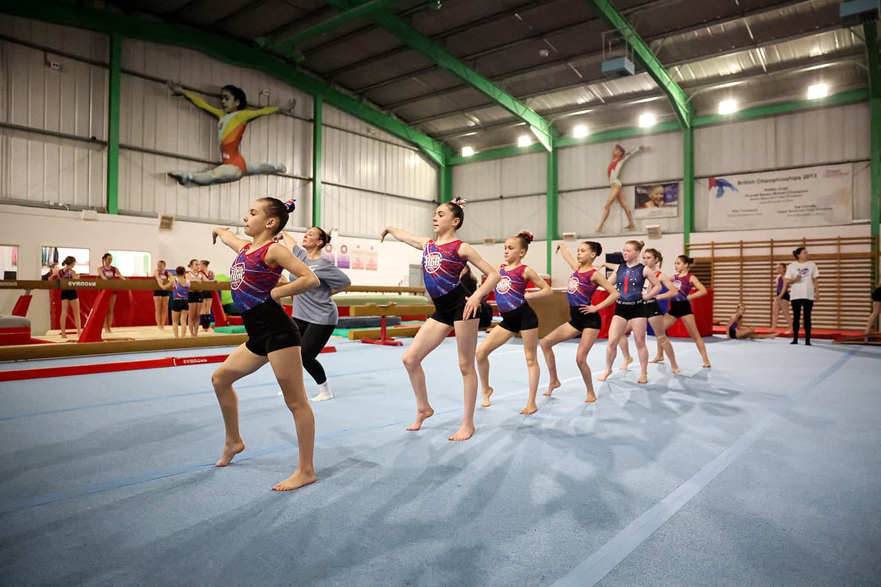 Gymnastics coaches working together in a training hall